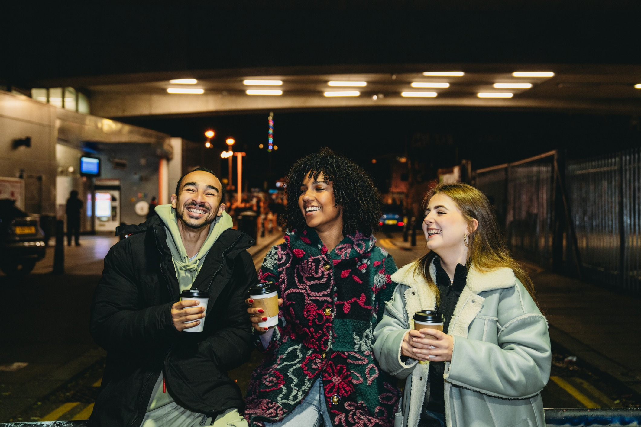Three friends get coffee between classes in a college town.