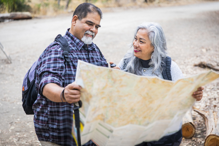 Middle-Aged Couple Look at Guide Map While On A Vacation Made Possible By Interest They Earned On An Alliant Certificate.