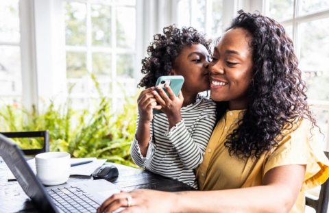 Mom and child happily filing taxes for 2025