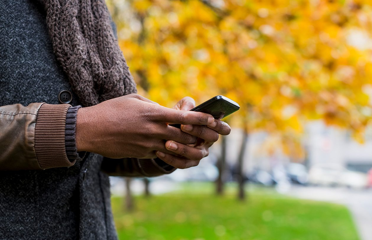 man outside in fall on mobile phone