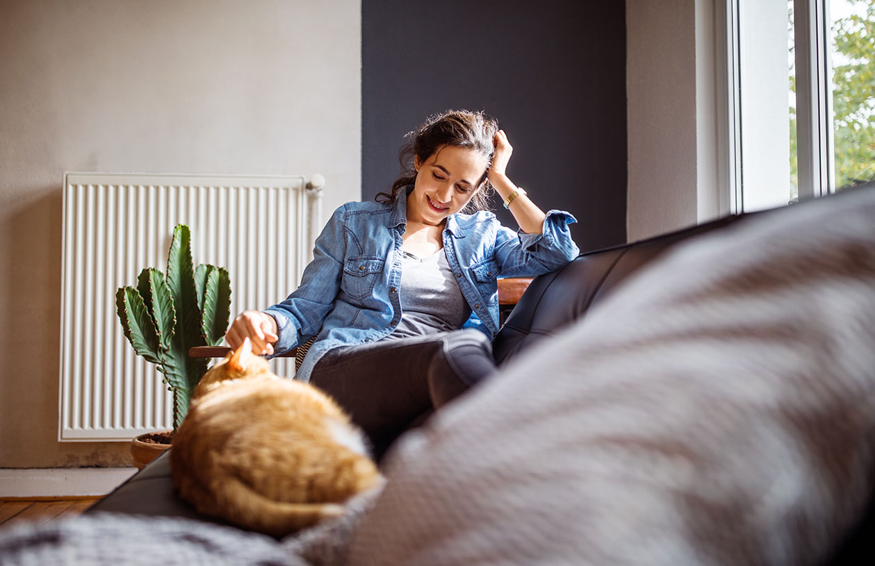 Woman with cat ponders how to save to buy a house