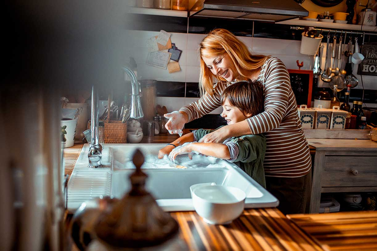 mother washing dishes with son