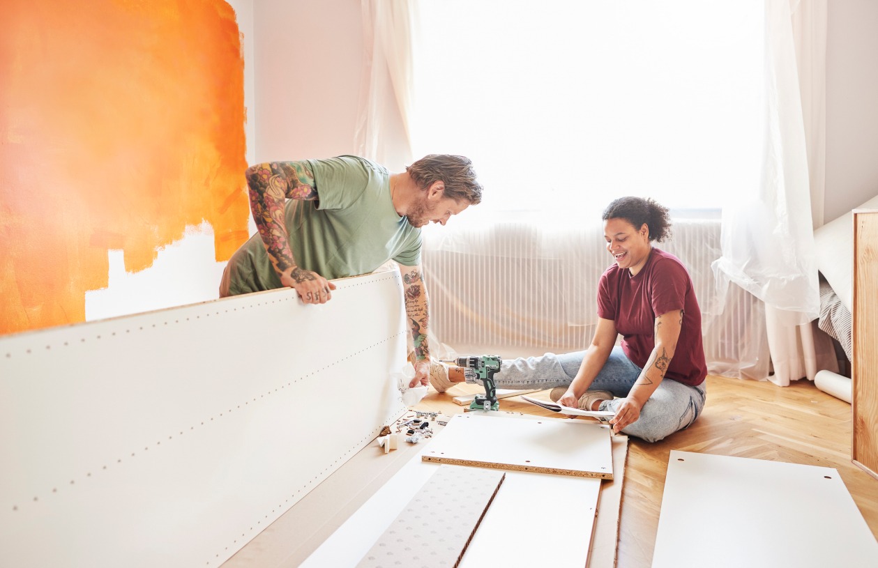 A man and a woman on the floor of their home doing a home improvement project